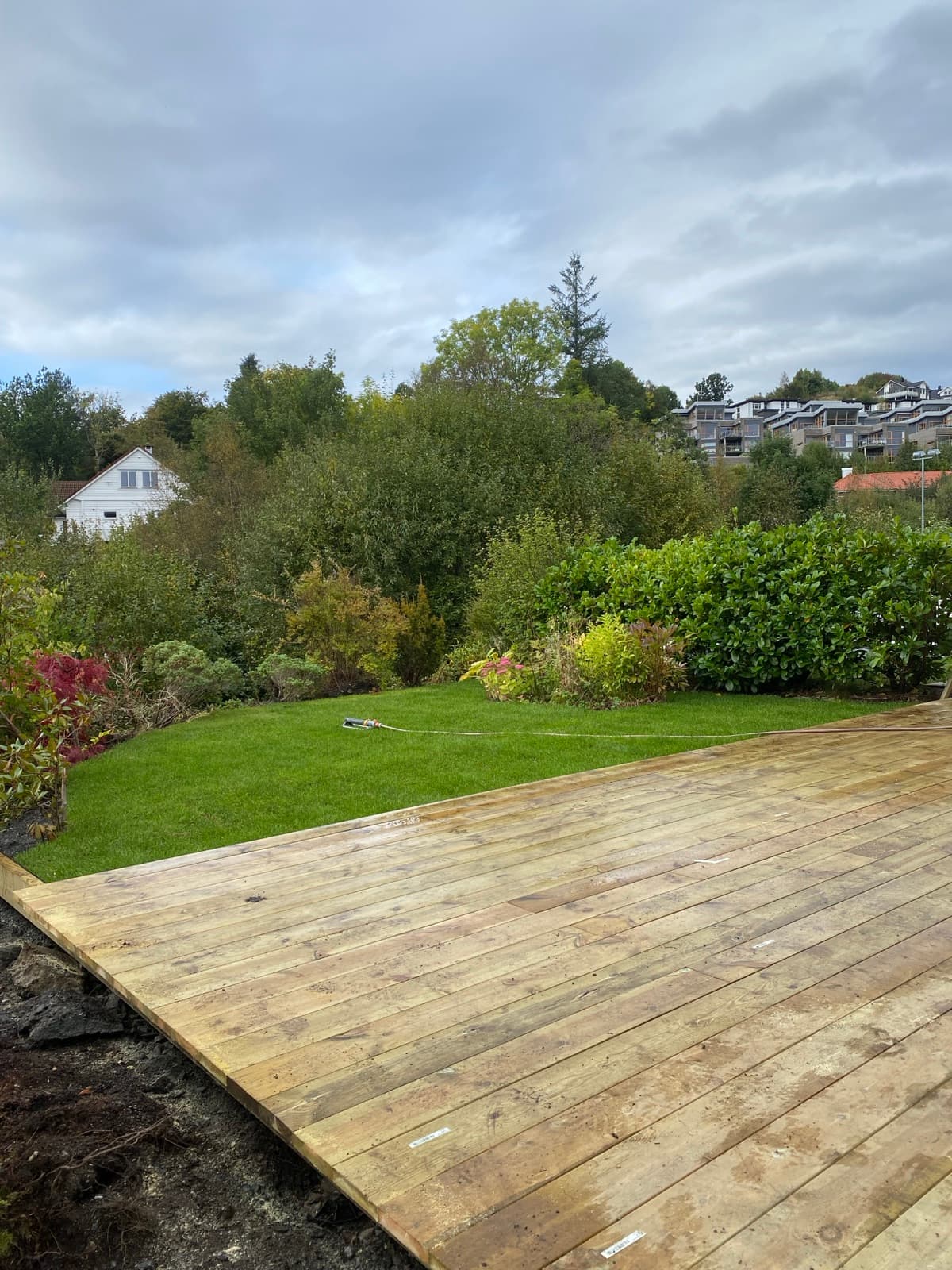 Privat hage med terrasse, ferdig plen og frodig beplantning